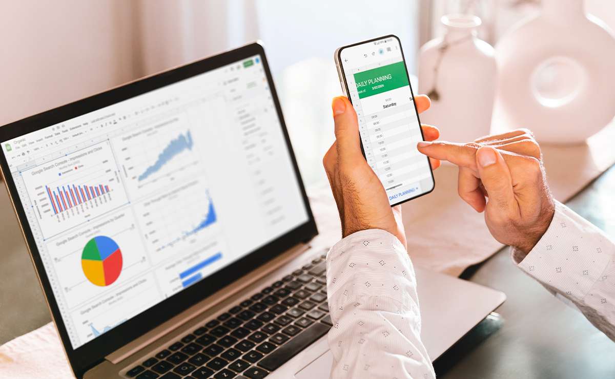 Persona che utilizza Google Sheets su laptop e smartphone