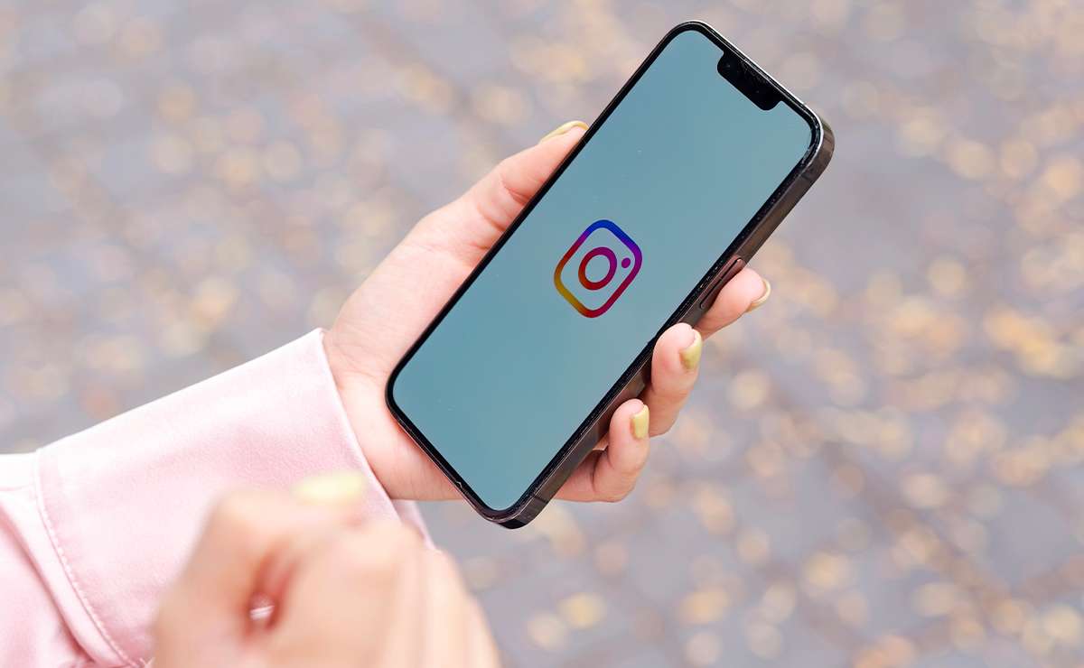 Smartphone tenuto in mano con logo Instagram sullo schermo