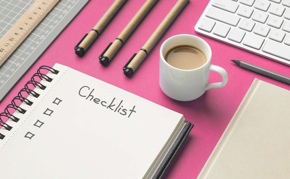 Taccuino aperto con la scritta “Checklist” e caselle da spuntare