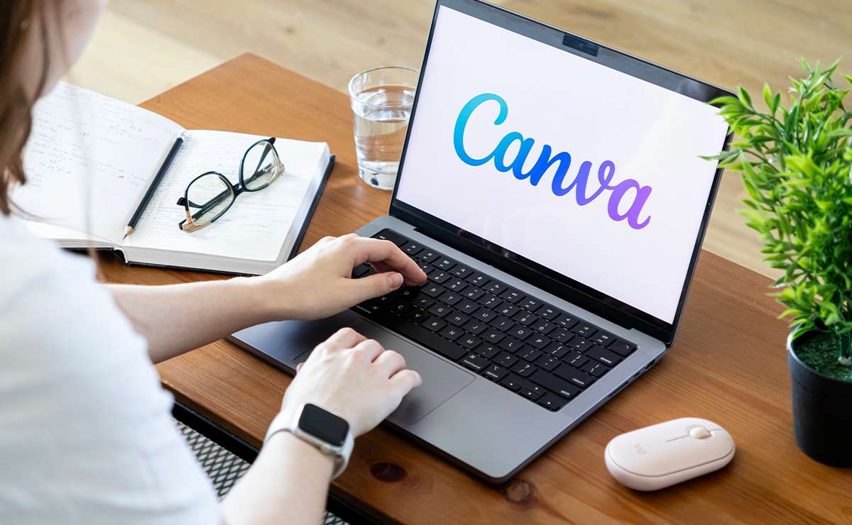 Mani su tastiera del computer con Logo Canva sullo shermo