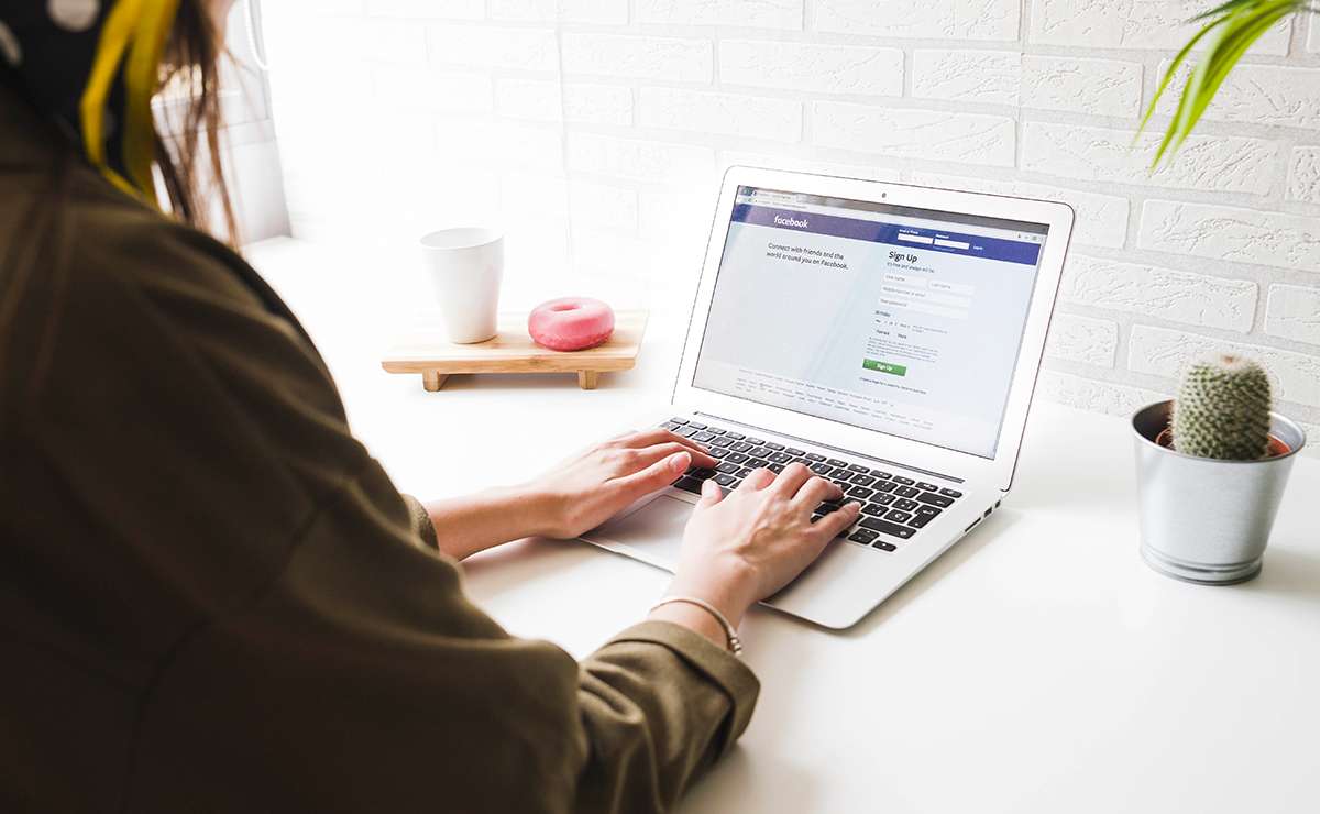 persona scrive al pc schermata pagina facebook