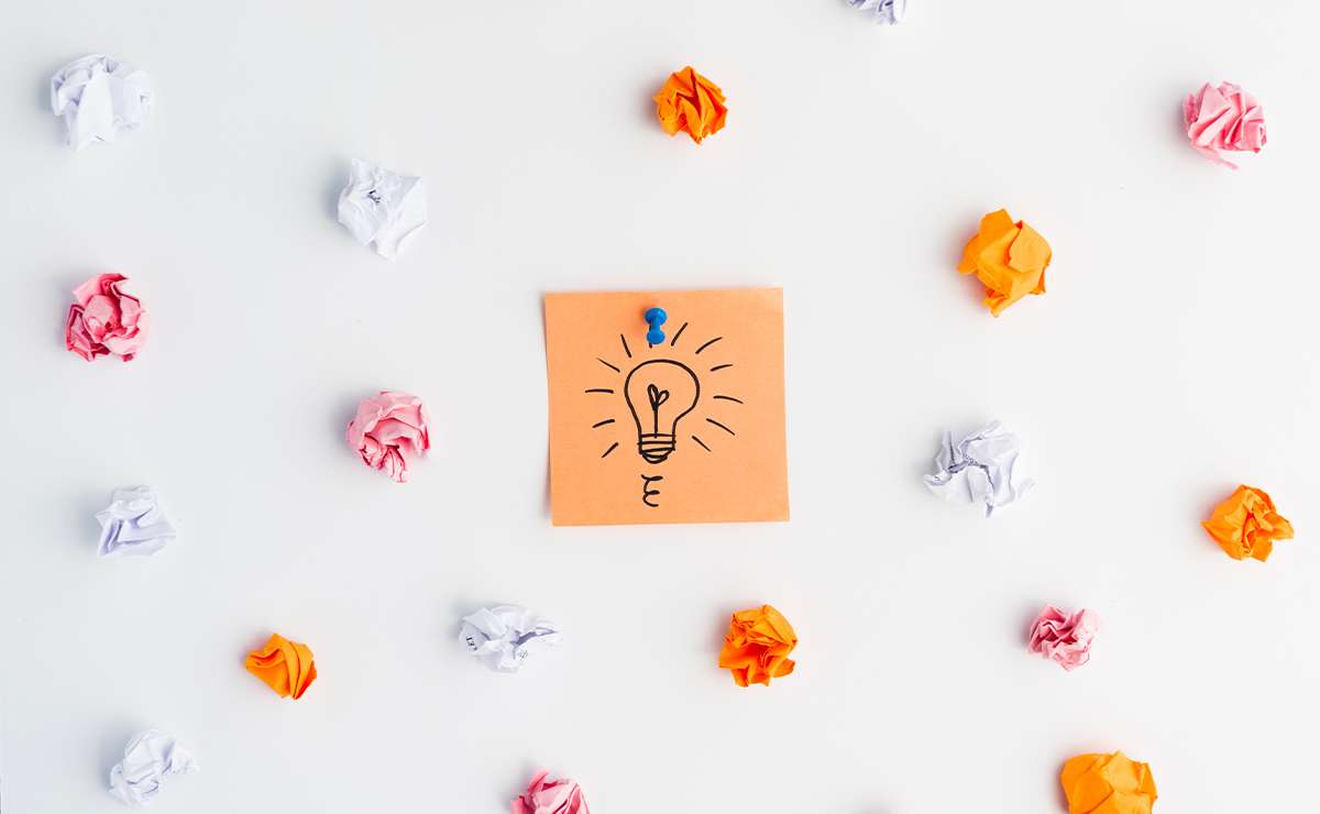 Post-it con disegno di una lampadina al centro, circondato da fogli accartocciati colorati
