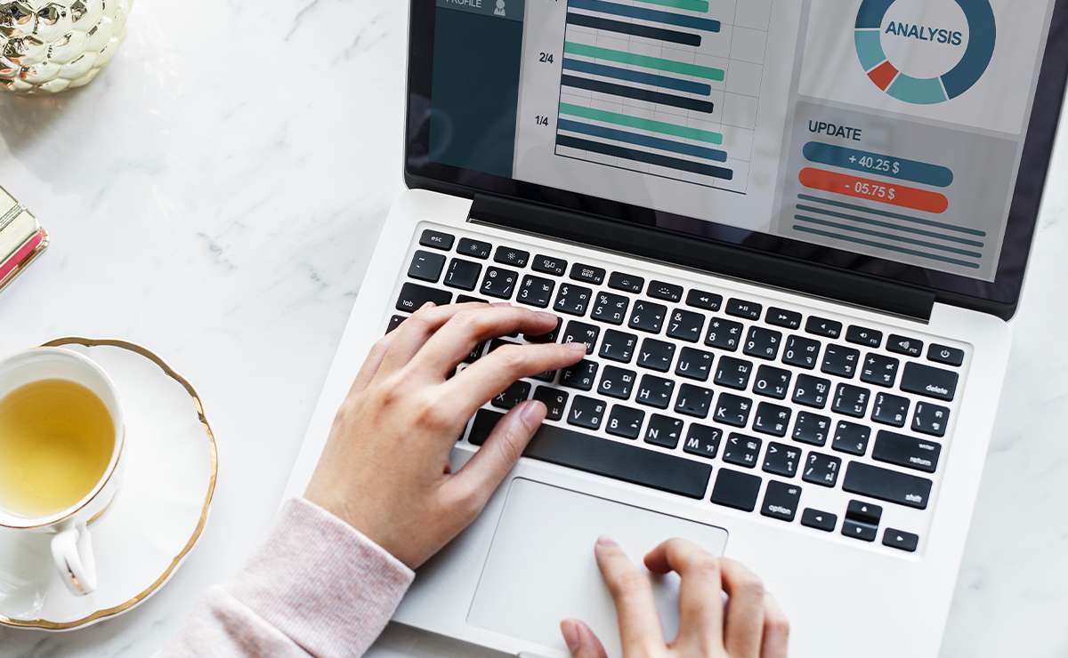 mani di donna su tastiera pc portatile con schermata di analisi